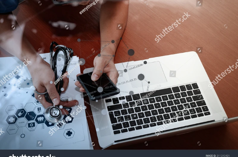 Médico usando laptop e smartphone para estratégia de marketing médico em Ribeirão Preto